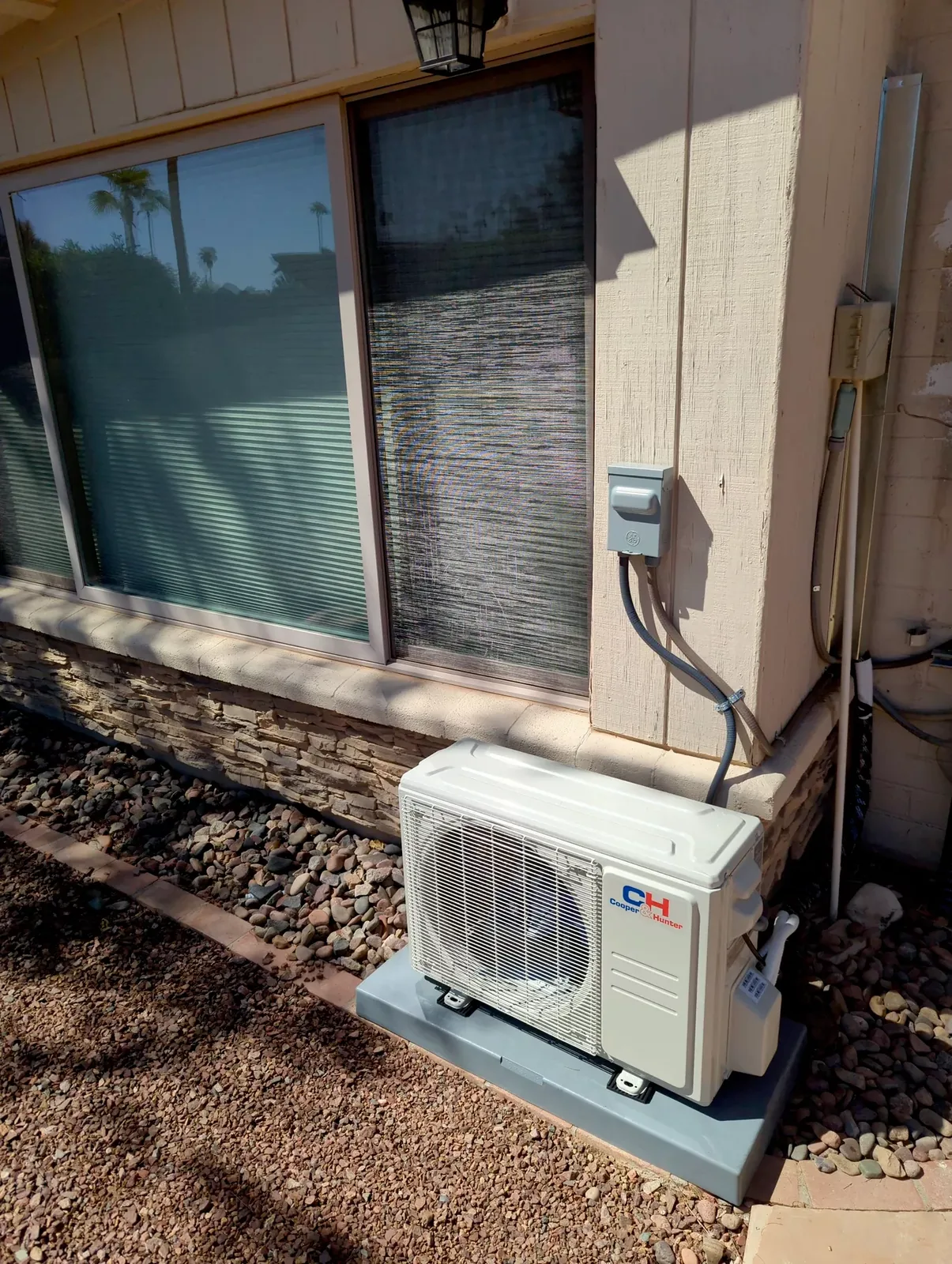 Cooper & Hunter ductless mini-split condenser on a ground pad beside a Phoenix home